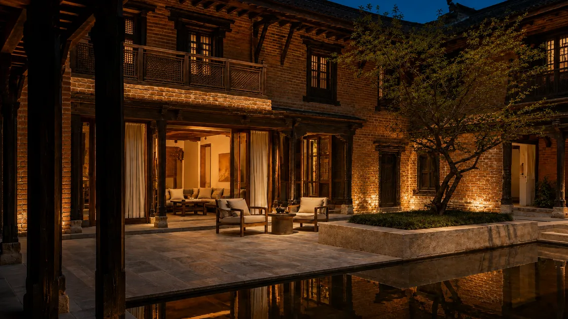 The same imagined courtyard after dark, with warm light from the lounge