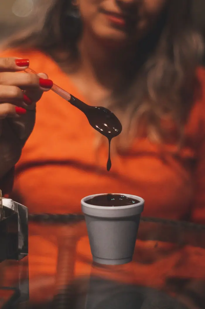 Woman holding a spoon of melted chocolate