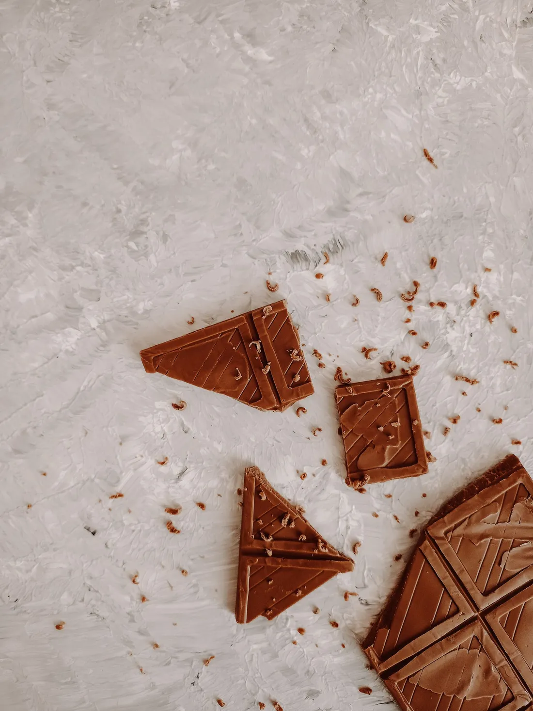 Close-up photograph of broken dark chocolate bar pieces