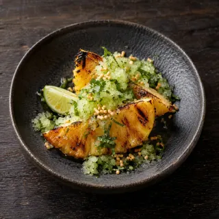 Two golden chargrilled pineapple wedges with shiso granita, lime and a little toasted rice