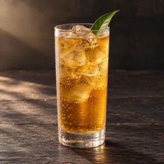 A clear amber sparkling cold oolong tea in a simple tall clear glass with ice and a small green peach leaf. No fruit chunks, alcohol bottle or branding