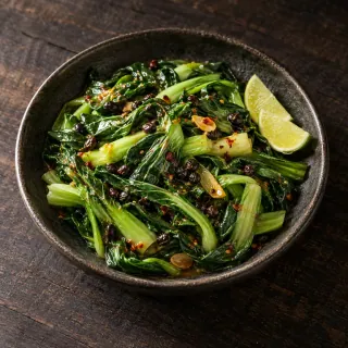 Glossy wok-tossed leafy greens with fermented beans, lime and a little chilli oil