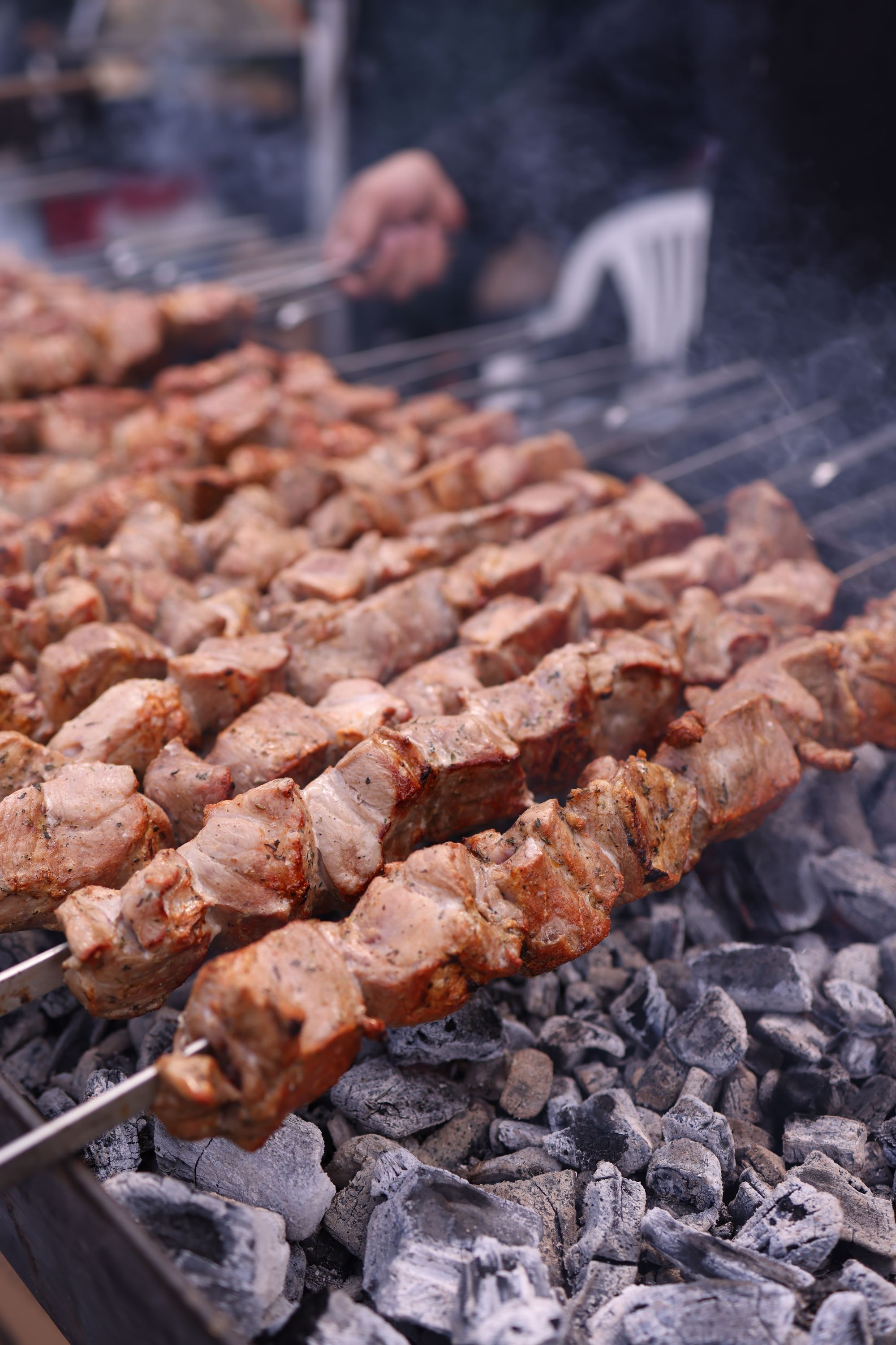 Skewers cooking above a glowing charcoal bed