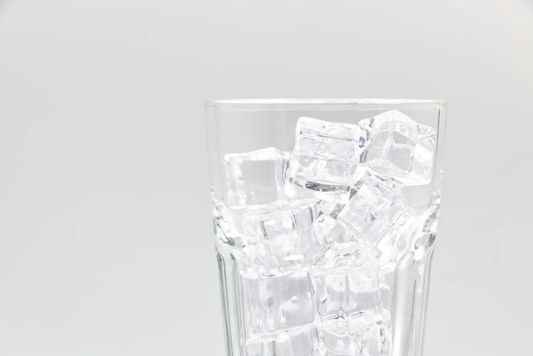 A glass filled with clear ice cubes