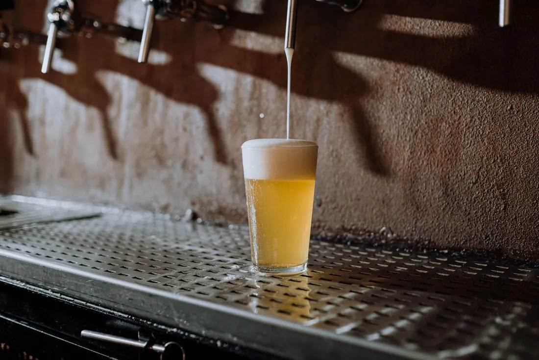 Golden beer pouring from a tap into a glass