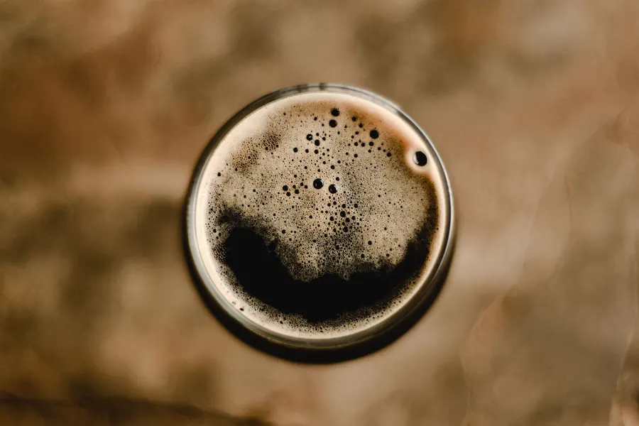 Top-down view of a dark stout with a tan foam head