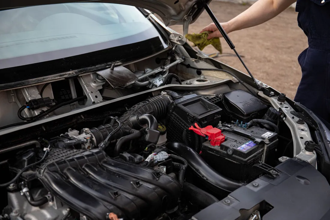 Mechanic inspecting an engine bay with the hood open