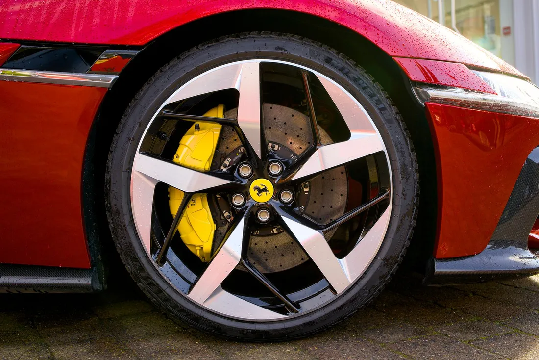 Red six-piston performance brake caliper behind an alloy wheel