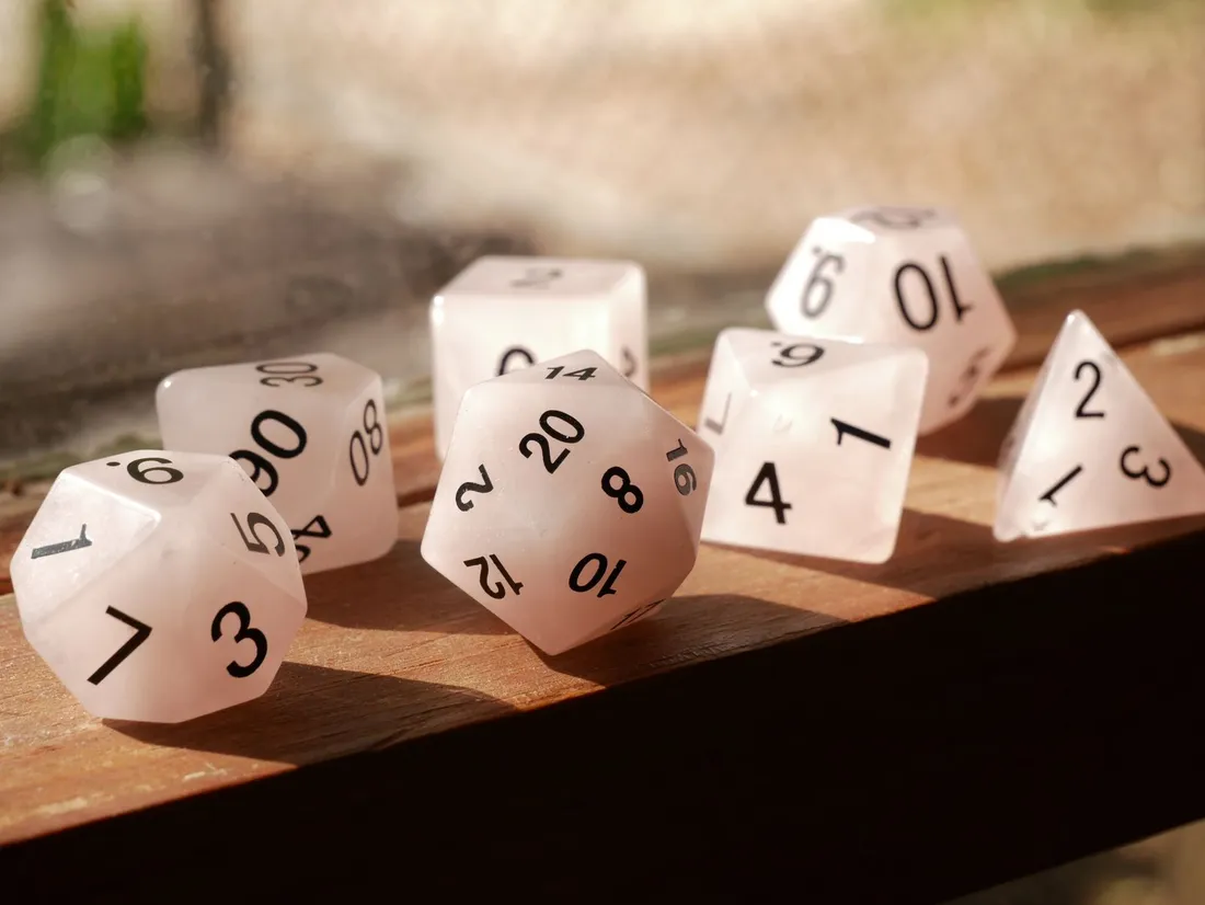 Polyhedral dice scattered on a wooden surface