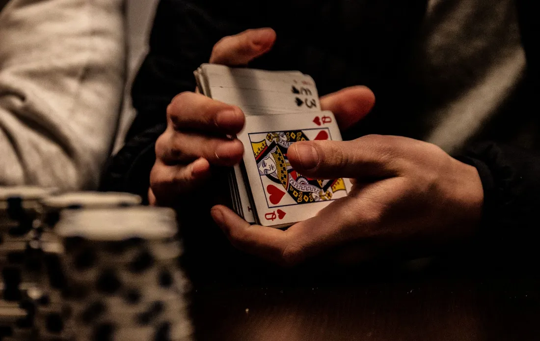 A person holding a hand of playing cards