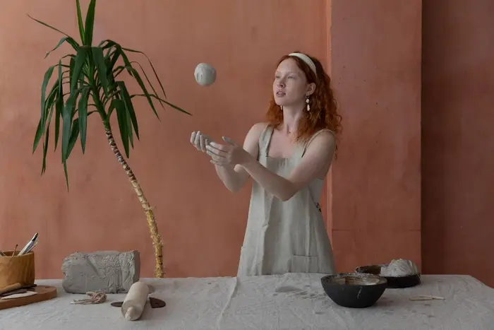 A potter throwing a ball of clay