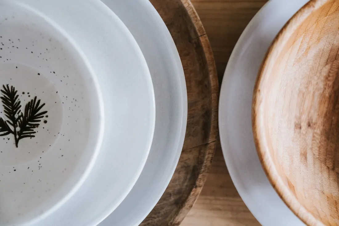 White speckled ceramic side plates stacked with a wooden bowl