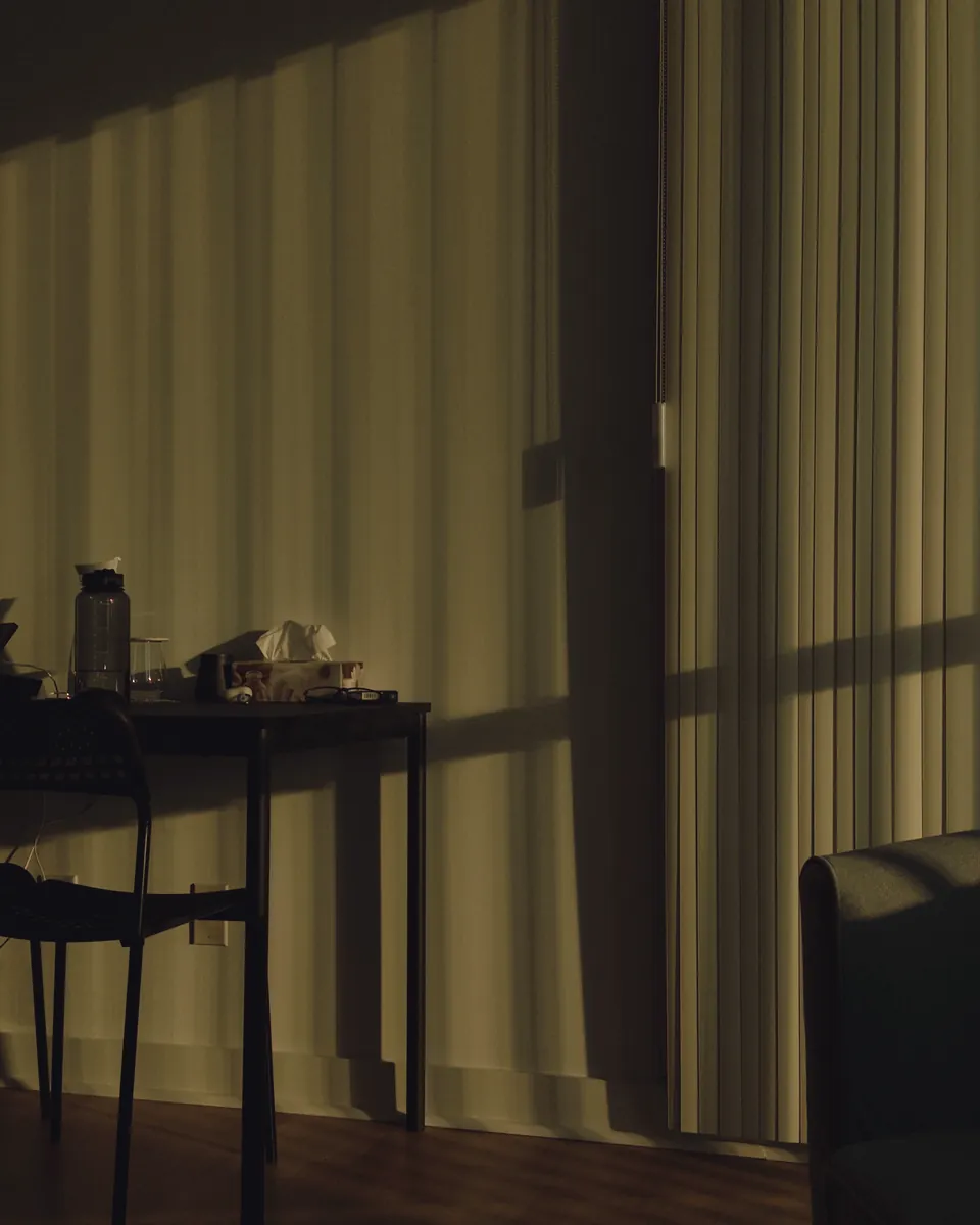 A quiet room before class, daylight diffusing through a full-height curtain