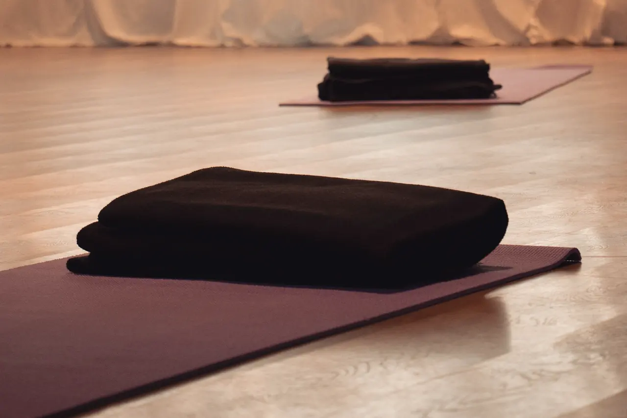 The Alcove set up for breathwork: a folded blanket and a bolster on each mat