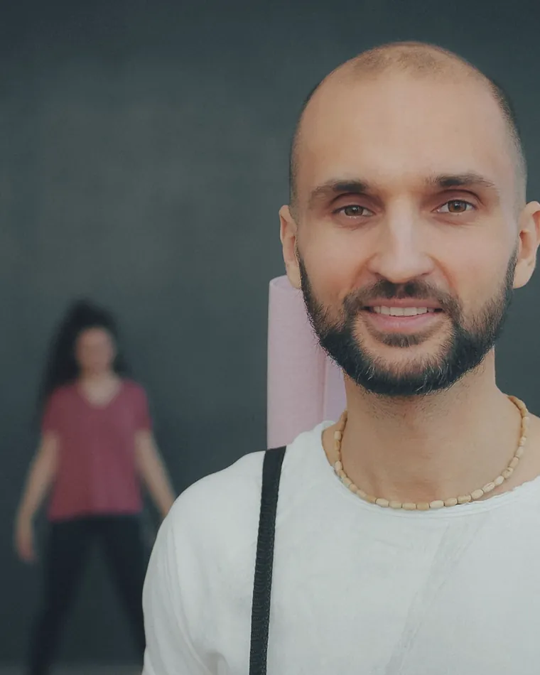 A teacher photographed in the studio while a class practises behind him