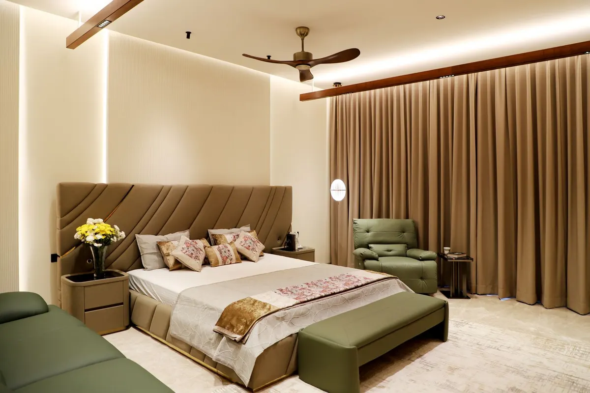 The primary suite's sitting area with a green leather chair beneath a wood-slat ceiling