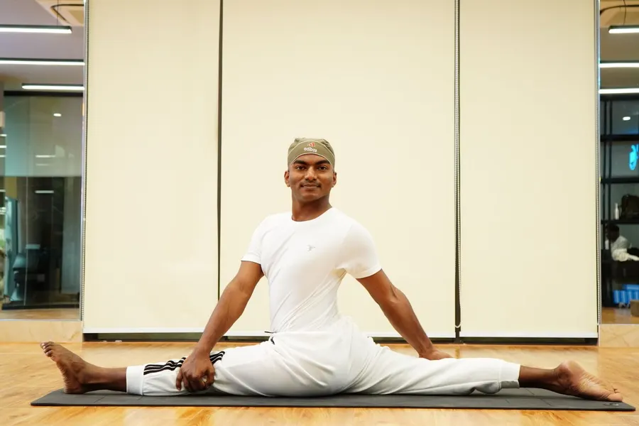 A man stretching his legs on a yoga mat