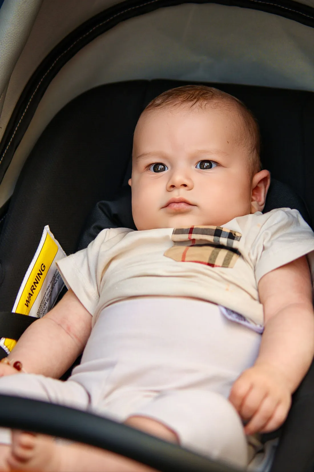 A baby seated in a stroller during a walk