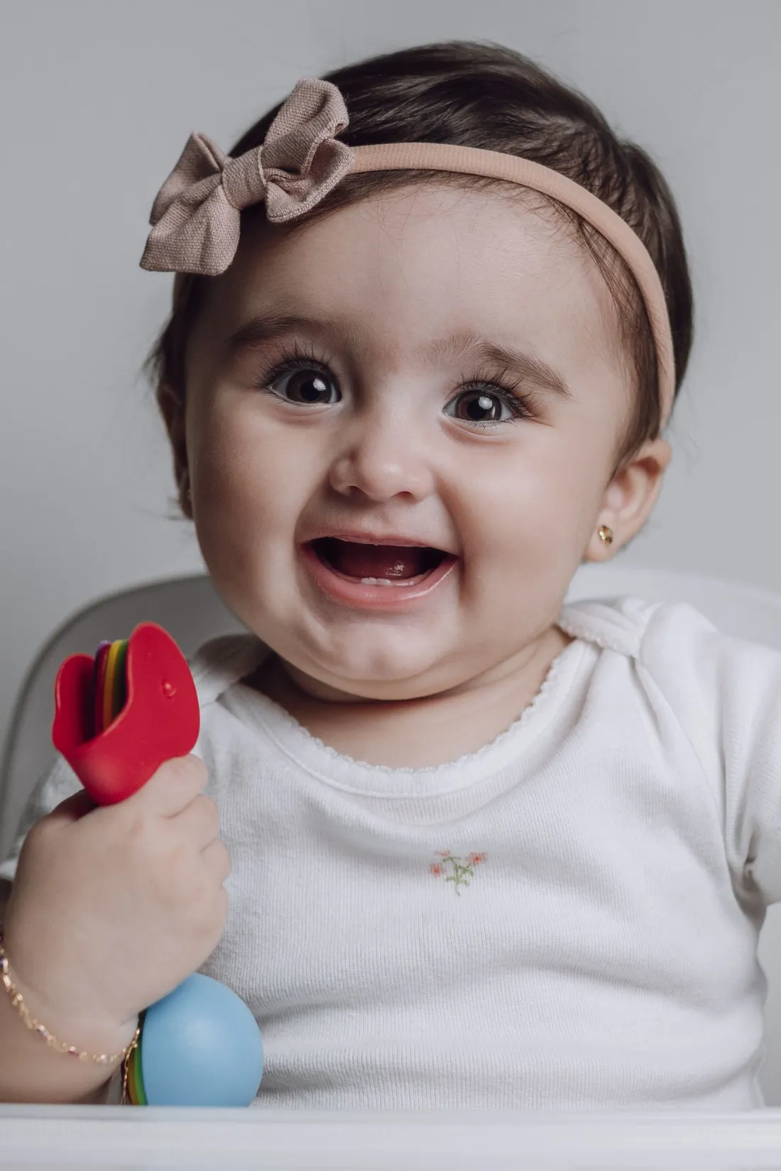 A young child sitting at a feeding chair