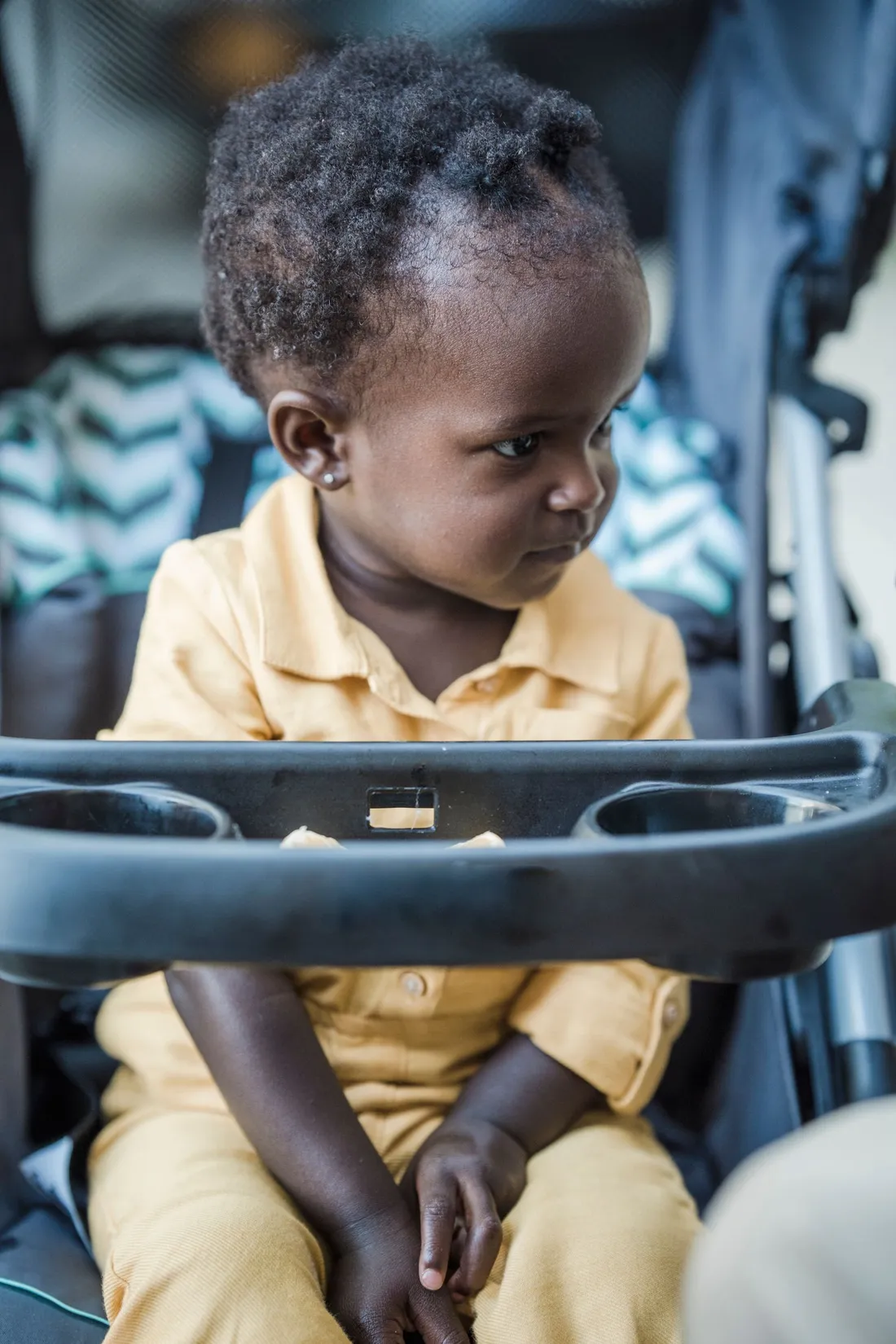 A baby sitting in a stroller outdoors