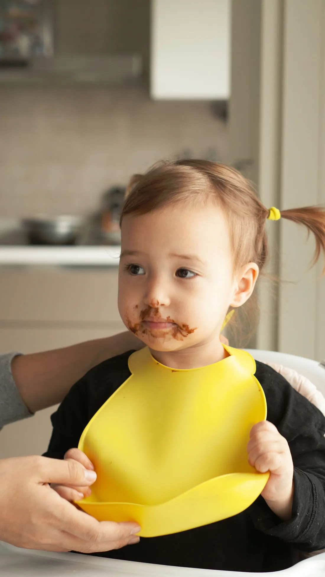 A toddler wearing a bib at mealtime