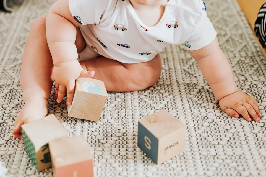 A baby playing with wooden blocks