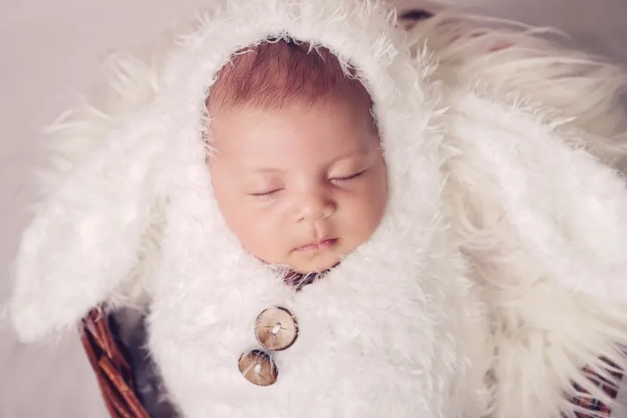 A baby sleeping peacefully in soft clothing