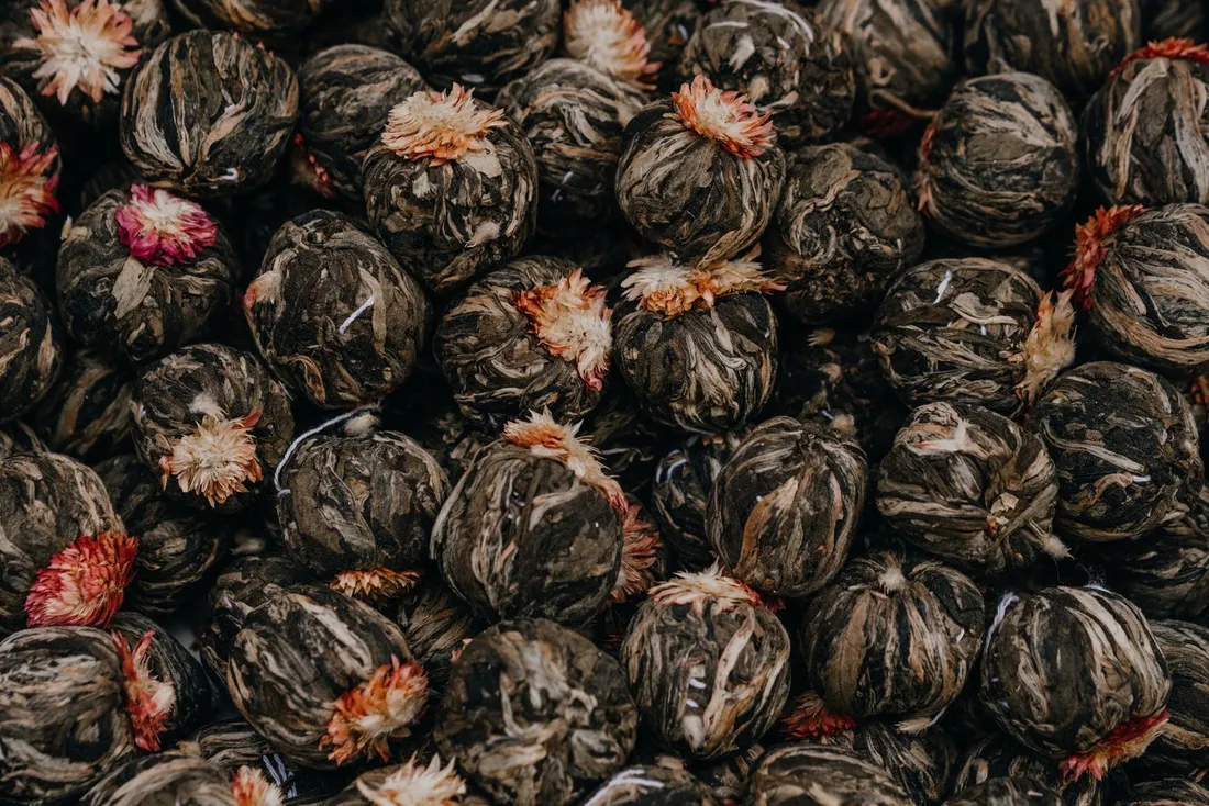 Small dried tea balls that unfurl into blooming leaf when steeped