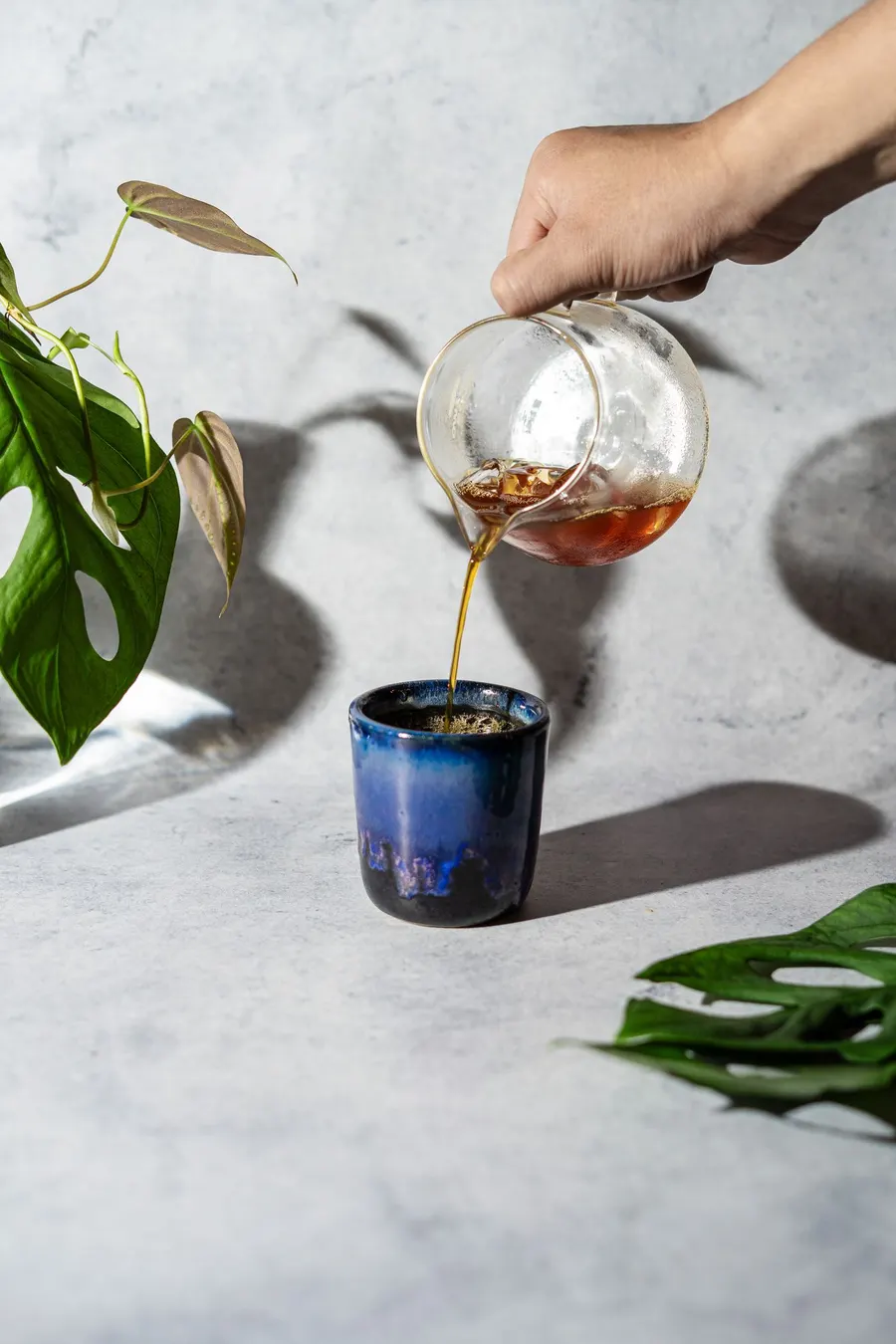 Tea being poured into a blue ceramic cup