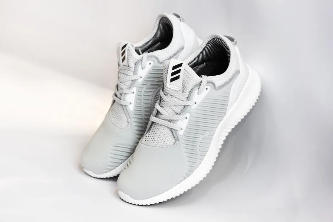 A lightweight minimalist running shoe against a grey background