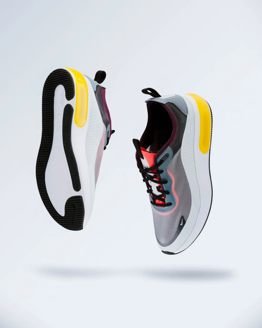 A pair of max-cushion running shoes on a plain background