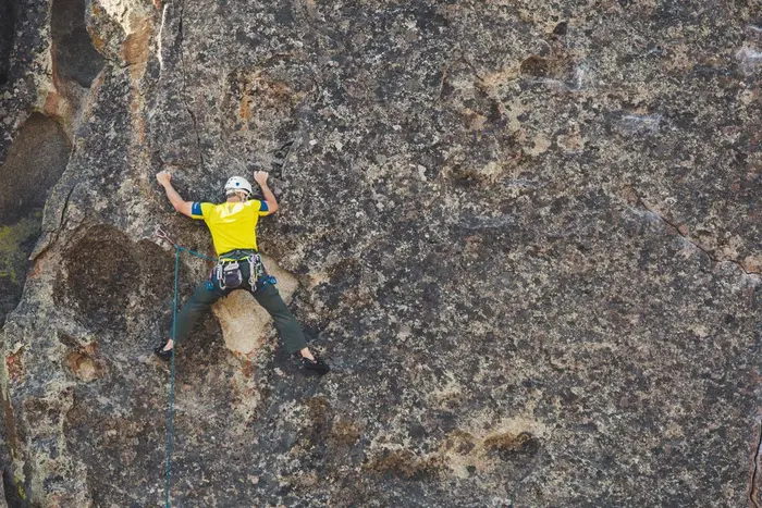A climber scaling a rock face outdoors