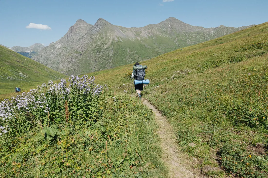 A hiker carrying a backpack while walking