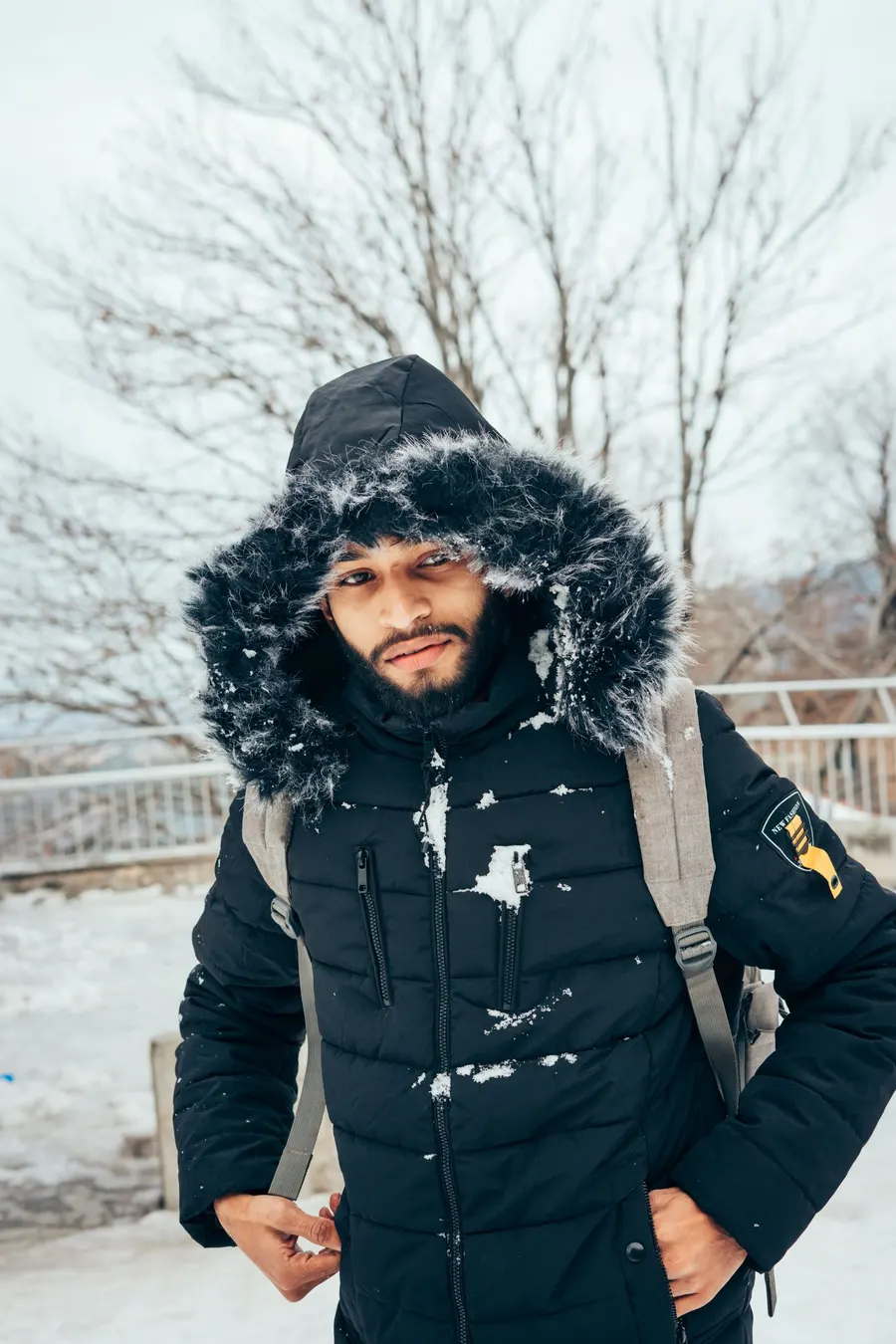A bearded man wearing a puffer jacket outdoors