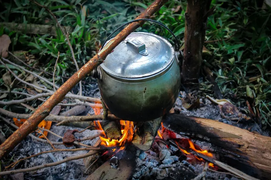 A cooking pot suspended over an open fire