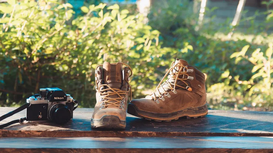 A pair of hiking boots resting outdoors