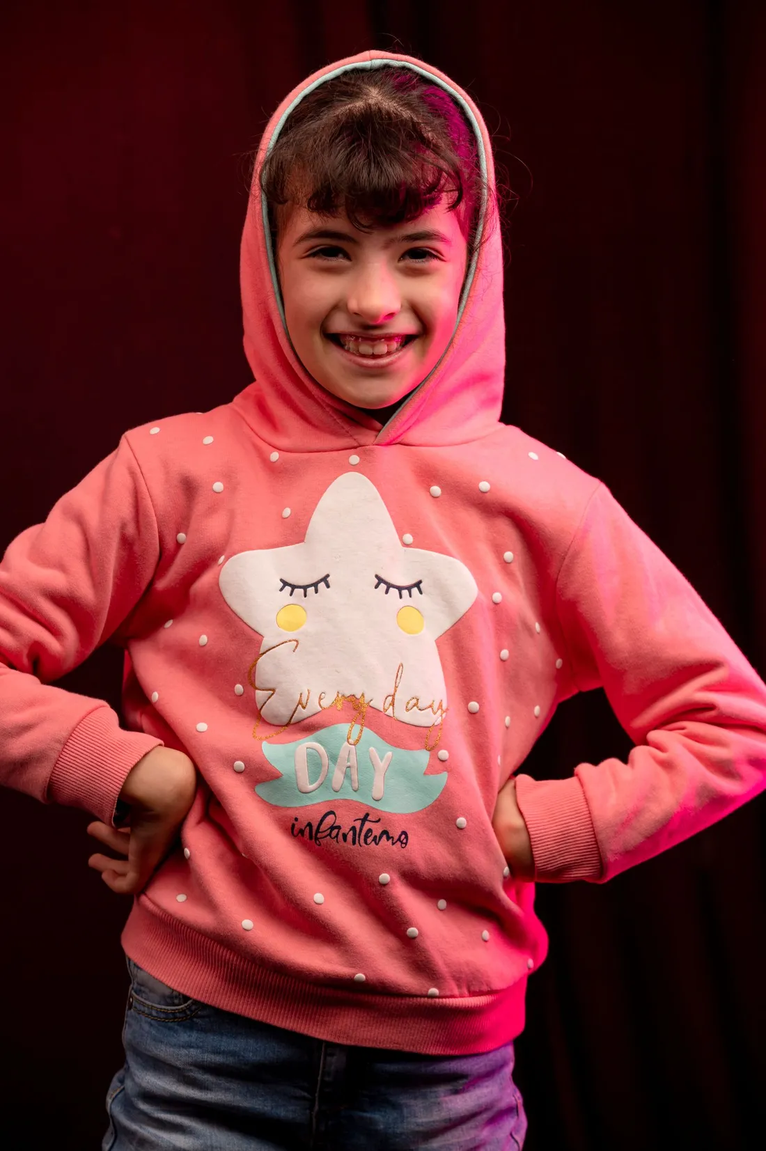 A young girl wearing a soft pink hoodie