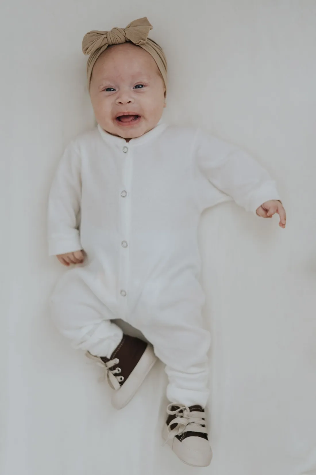 A baby wearing a soft white bodysuit