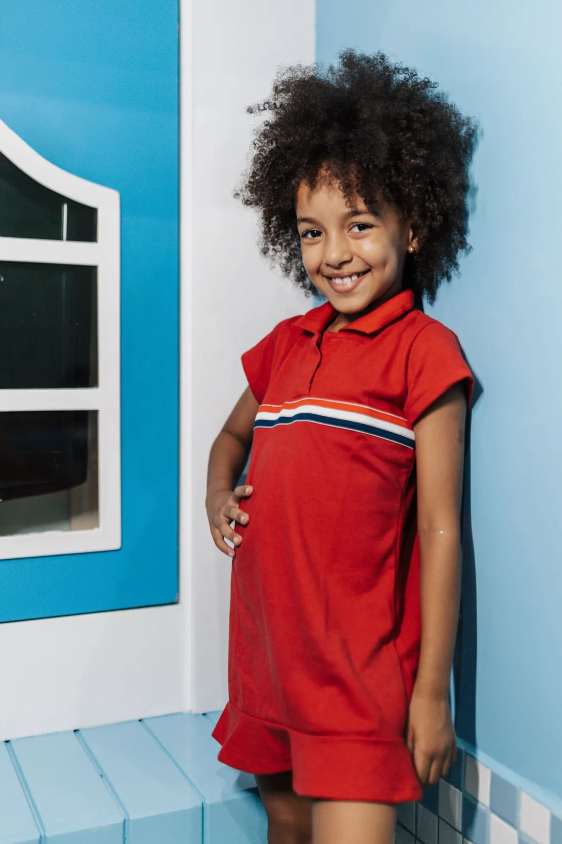 A smiling girl wearing bright red clothing