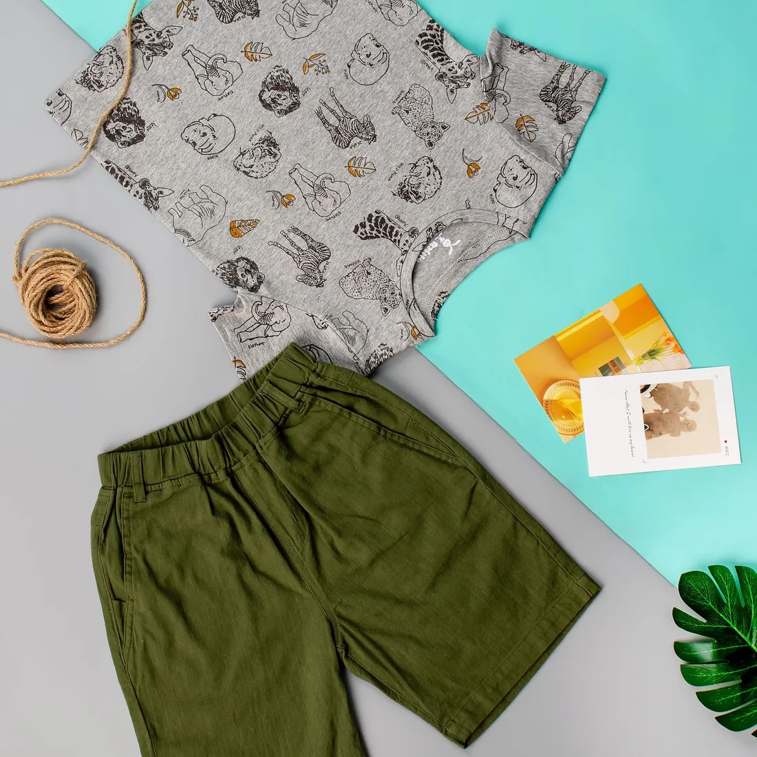 A bright yellow kids tee laid flat next to folded clothes