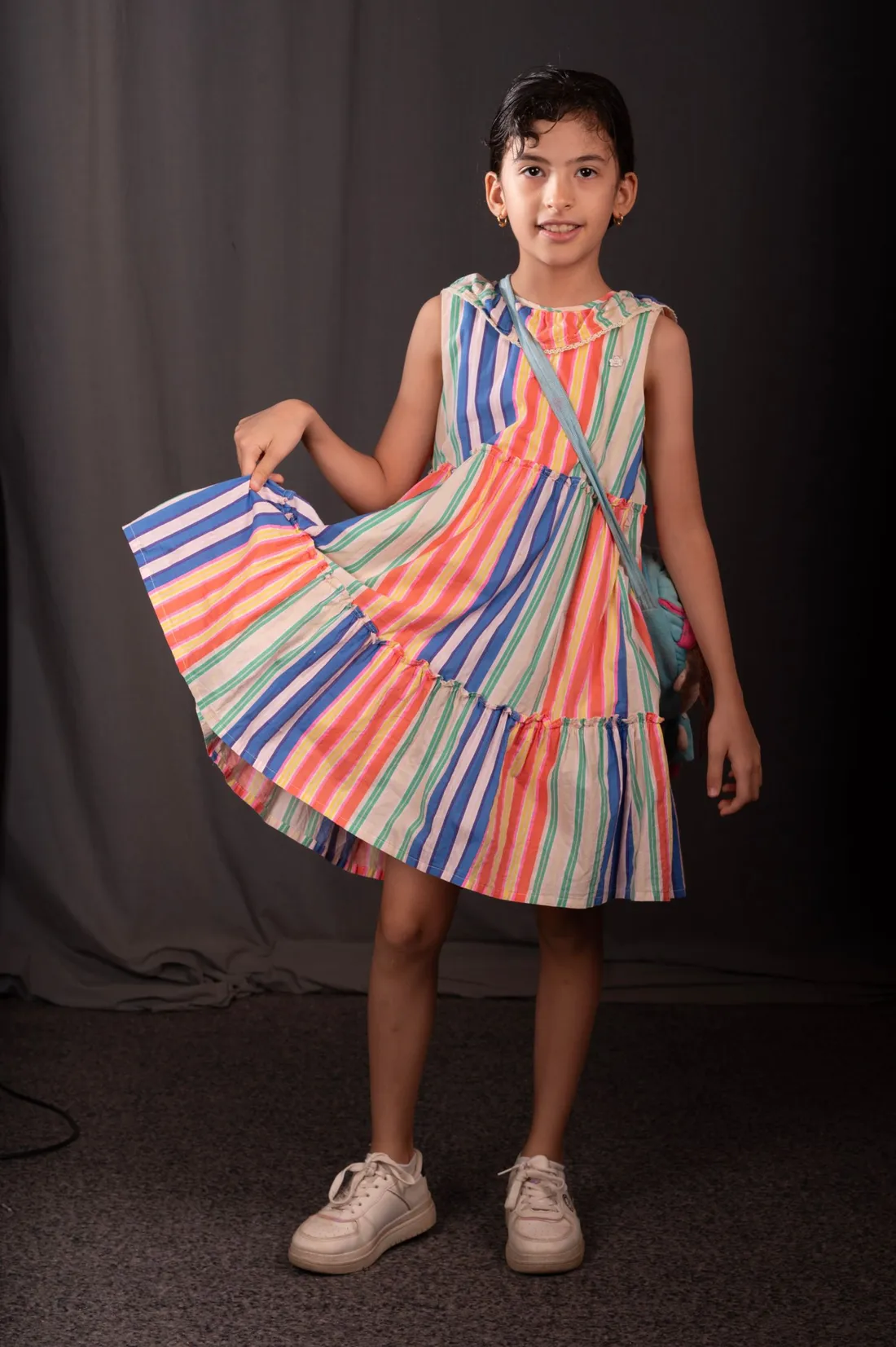 A young girl smiling in a colorful party dress