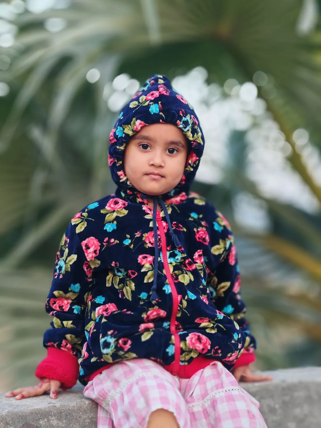 A child wearing a soft floral hoodie outdoors
