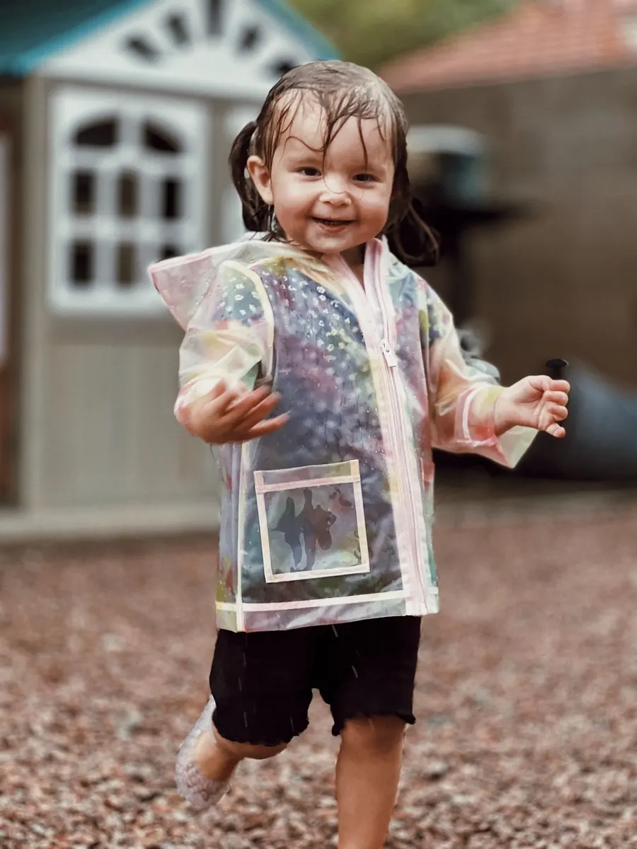 A child having fun in a raincoat on a rainy day