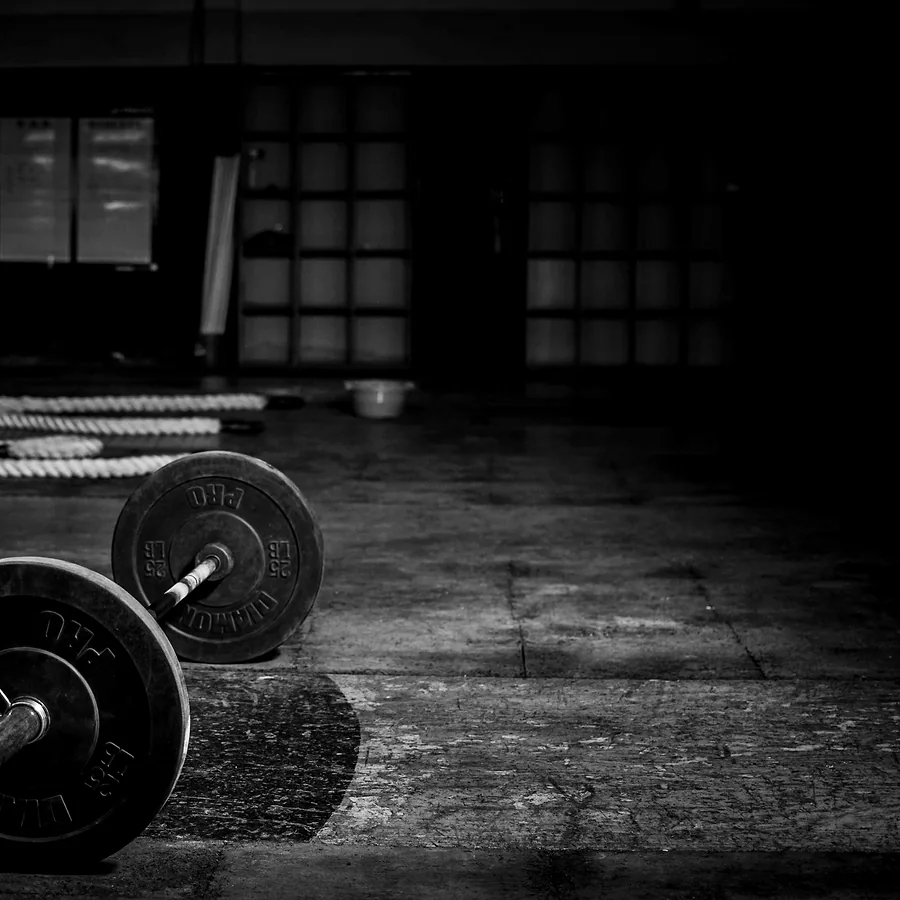 A loaded barbell resting on the worn studio floor