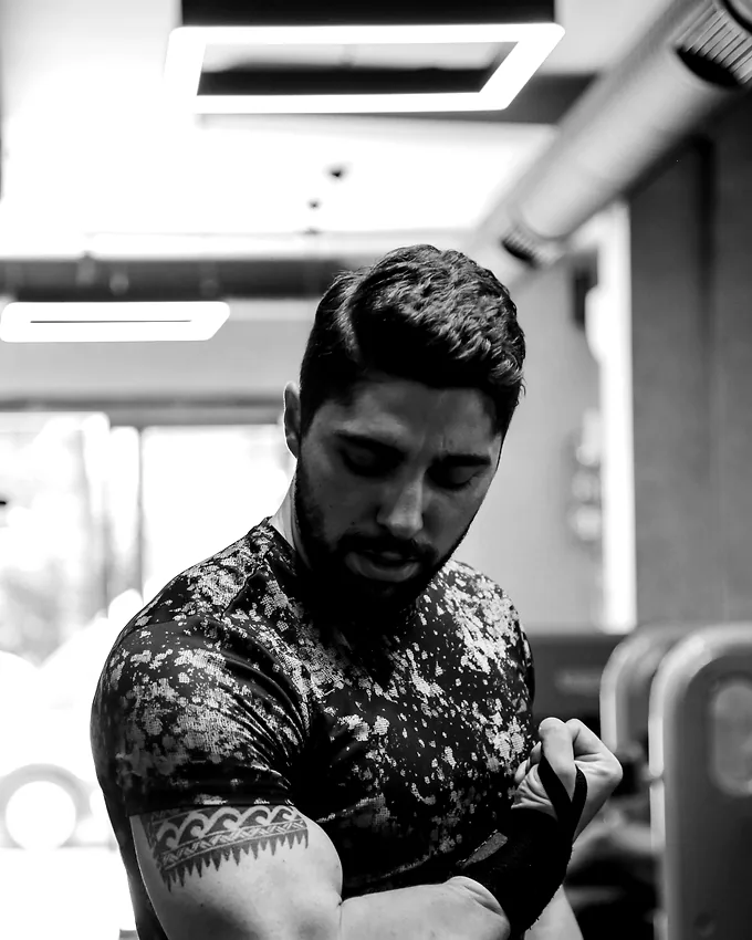 A member fastening a wrist wrap before a working set