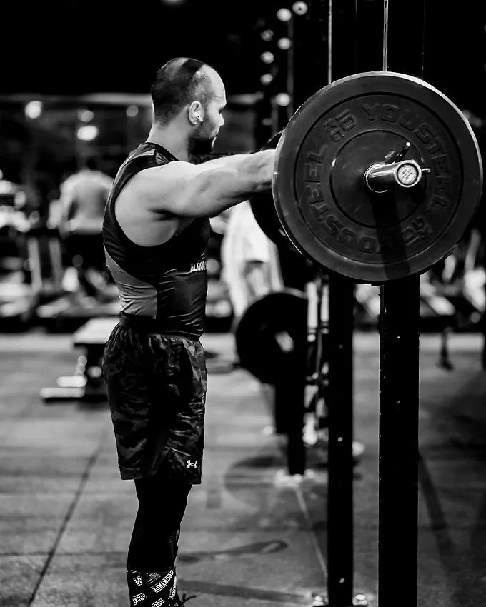 A member resting a bar across the shoulders between sets