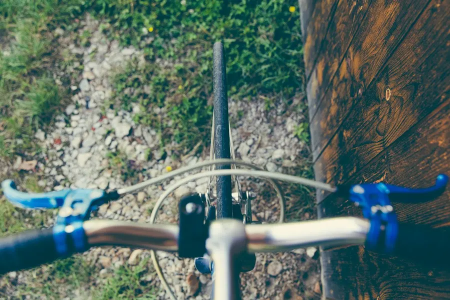 A gravel bike leaning against a wooden fence