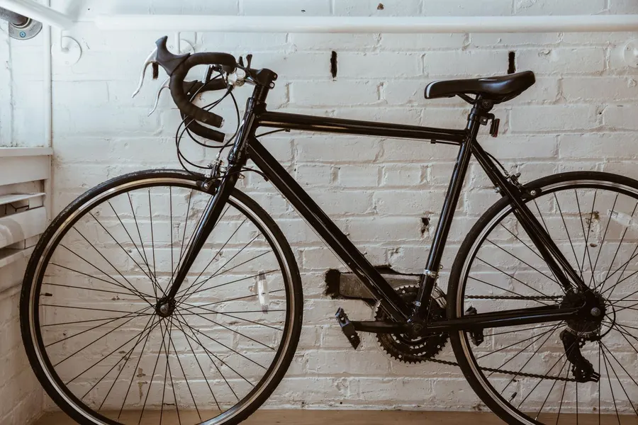 A parked road bike in front of a white brick wall