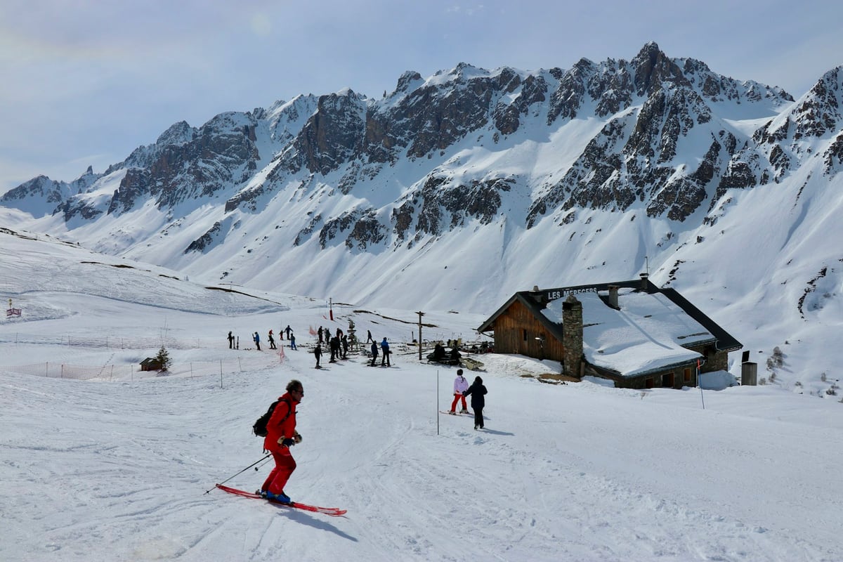 Skiers carving tracks down pristine snowy mountain slopes near the alpine lodge