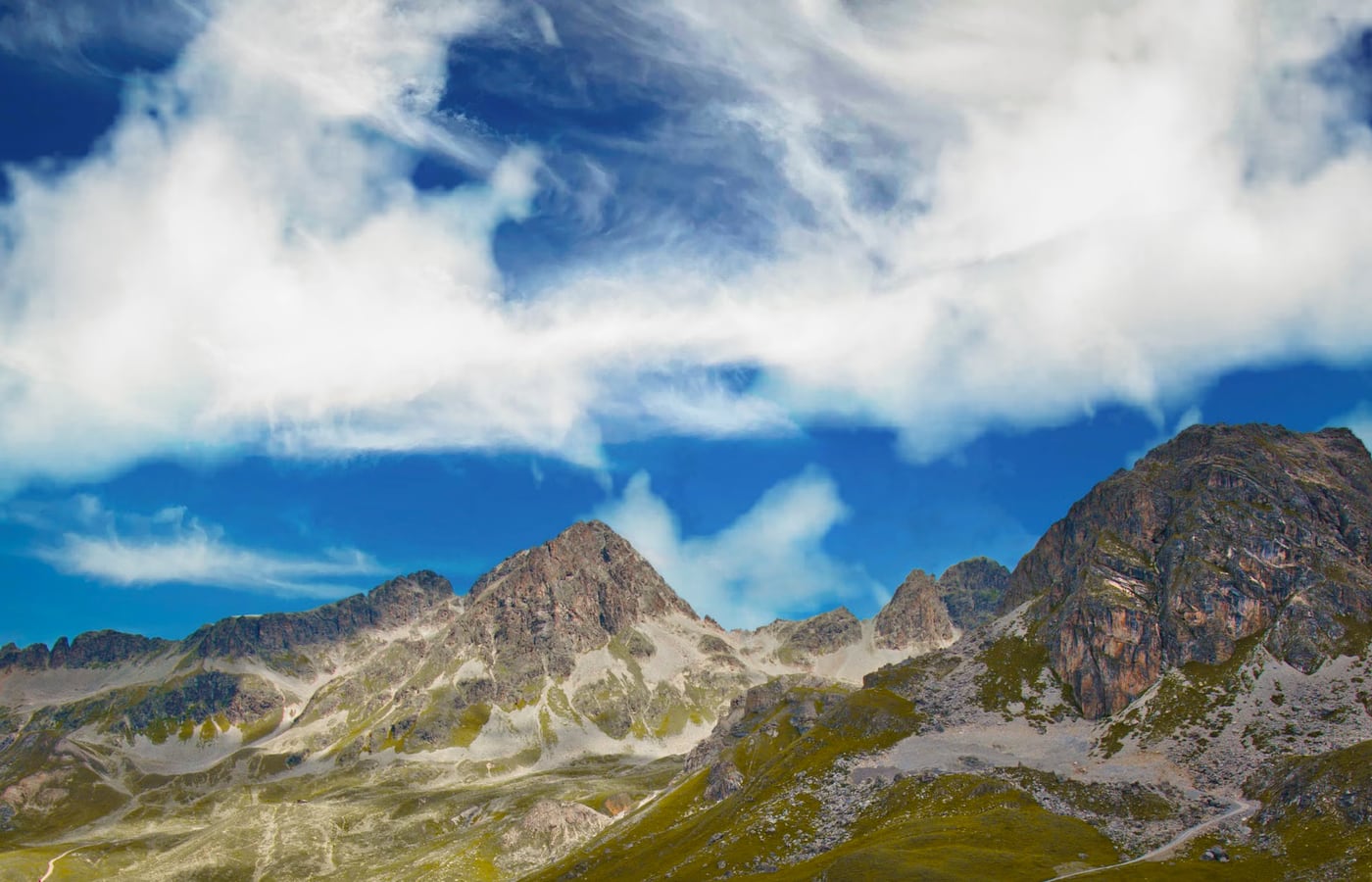 Summer in the Vesper Valley with emerald alpine meadows and sunlit crags